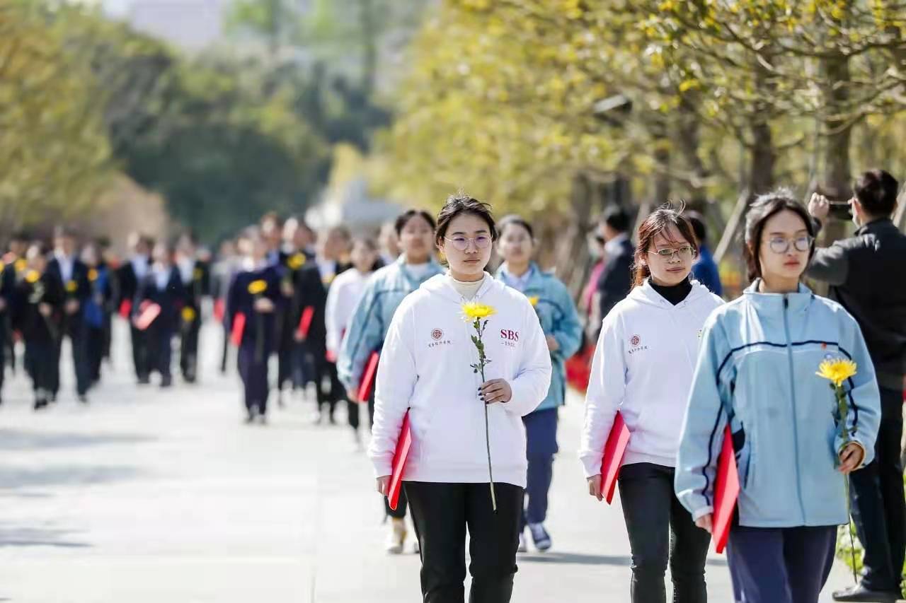 学生手捧菊花朝着龙华革命烈士纪念地出发